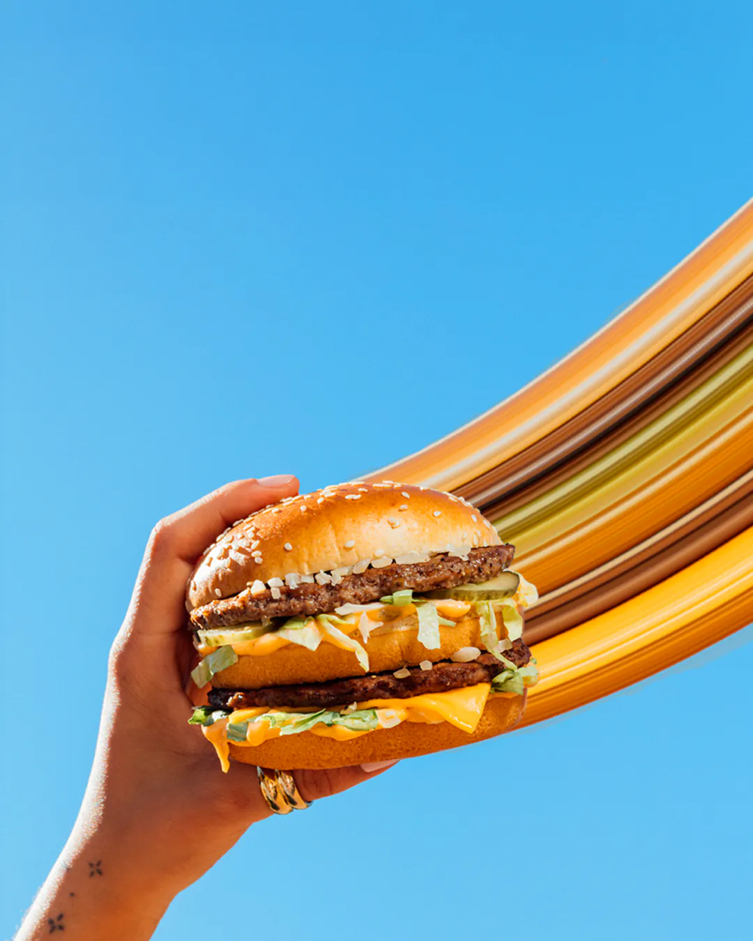 Hamburguesa Big Mac de McDonalds en la app Pide y Paga sobre fondo azul.